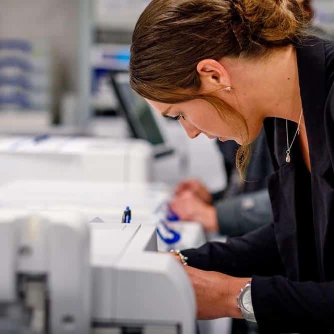 Vrouw aan het werk met het tekenen van kwaliteitspapieren in het magazijn van Abacus Medicine in Nederland