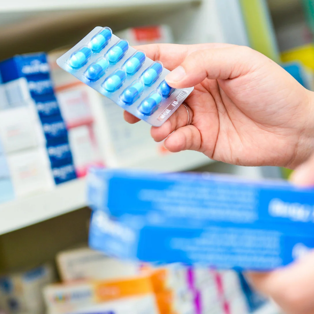 Medicine packaging and labelling in the UK: Requirements for medicine packs 1 A hand holding a blister of medicine examining the medicine packaging, the other hand holding two cartons of medicine packing in front of a shelf full of medicine boxes.