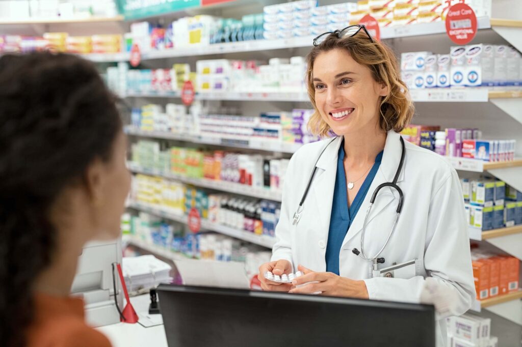Happy pharmacist helping customers